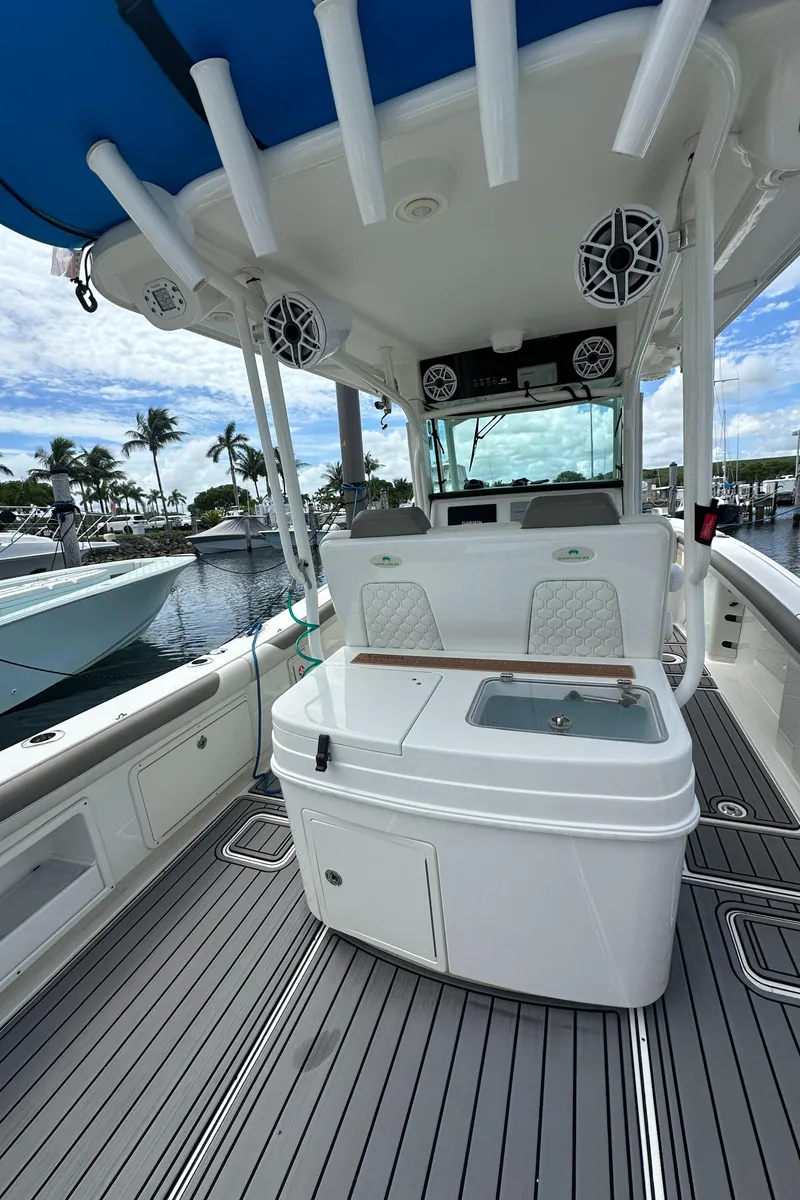 Slide: The Image of 2020 World Cat 325 CC boat interior with seating and storage, docked at marina. - 11