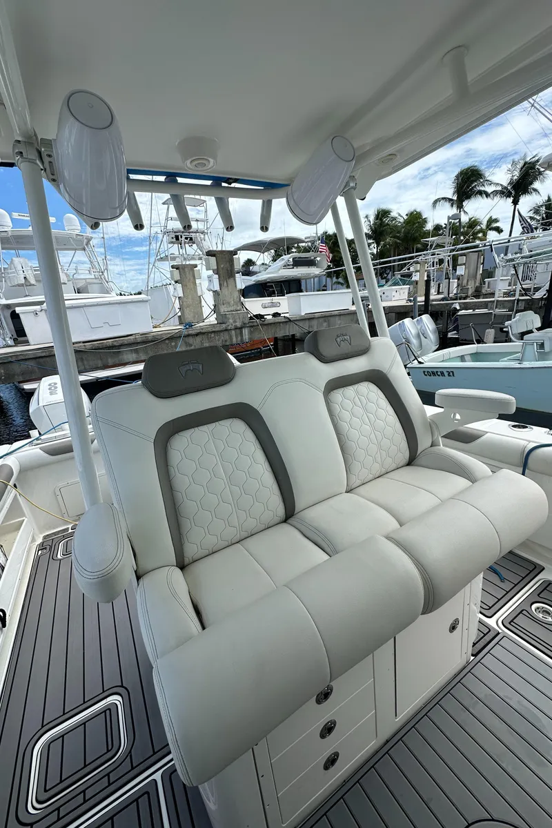 Slide: The Image of 2020 World Cat 325 CC boat with luxurious seating and marina background. - 15