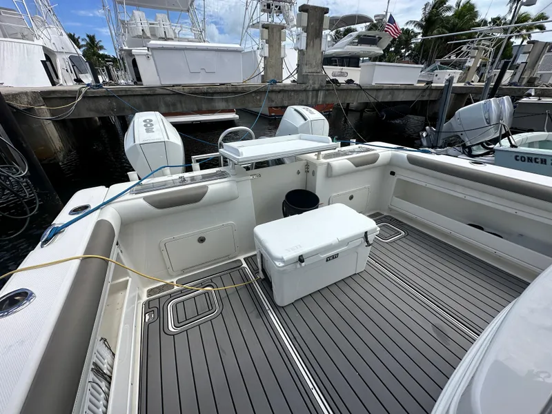 Slide: The Image of 2020 World Cat 325 CC boat deck with cooler, docked at marina. - 2