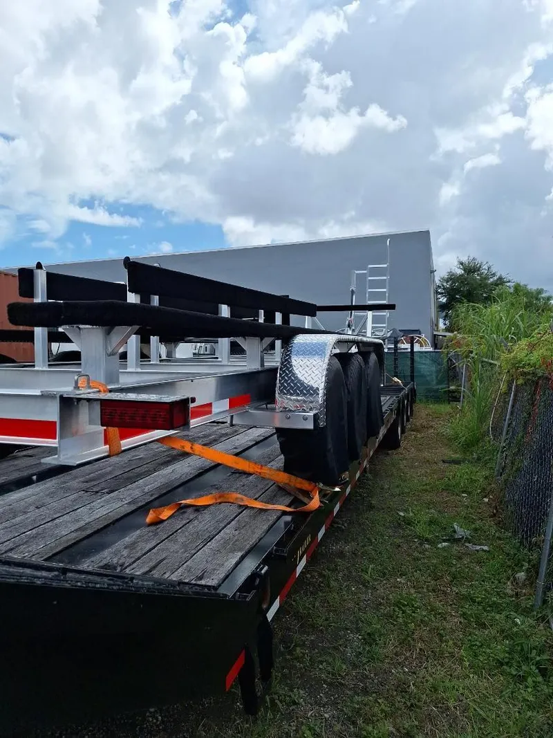 Slide: The Image of Trailer for 2020 World Cat 325 CC boat, parked outdoors under cloudy sky. - 23
