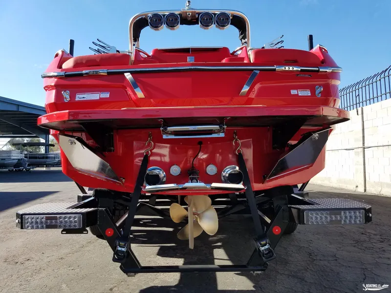 Slide: The Image of 2021 MasterCraft X26 boat, rear view, vibrant red color, parked outdoors. - 10