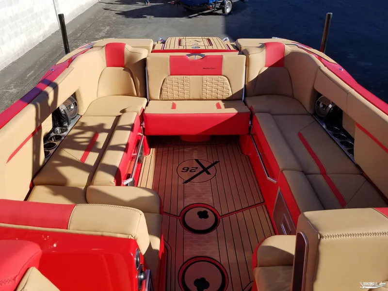Slide: The Image of 2021 MasterCraft X26 boat interior with red and tan seating, spacious layout. - 12