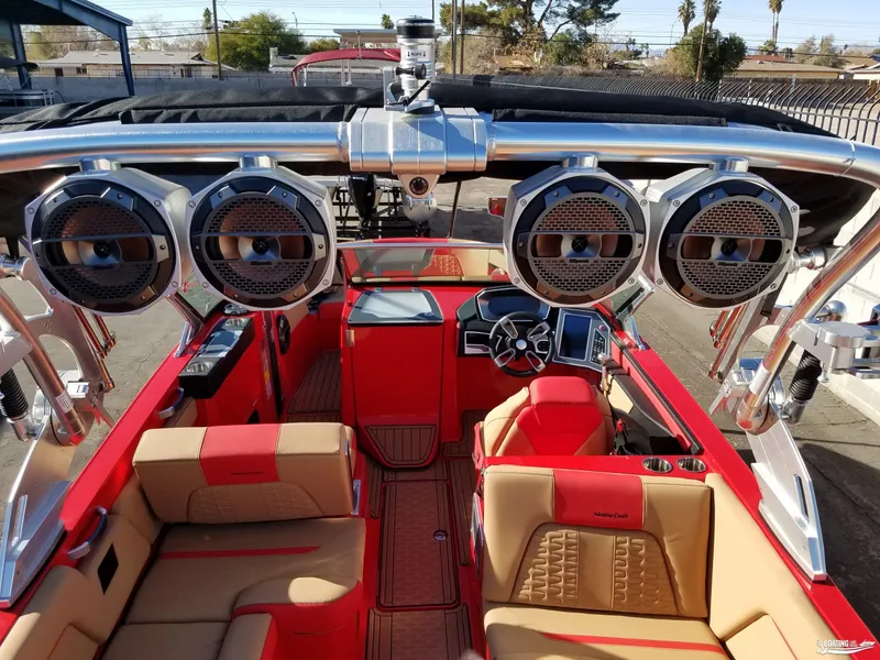 Slide: The Image of 2021 MasterCraft X26 boat interior with red and beige seating, advanced audio system. - 21