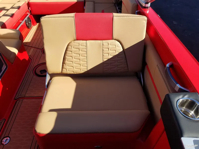 Slide: The Image of 2021 MasterCraft X26 boat interior with tan and red seating, cup holder, and stylish design. - 22
