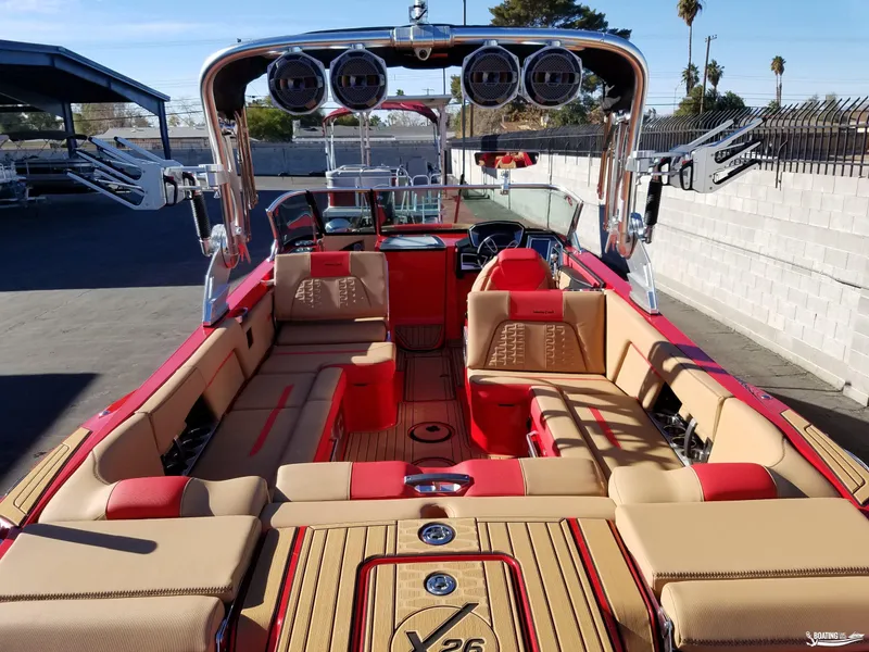 Slide: The Image of 2021 MasterCraft X26 boat interior with red and beige seating, outdoor setting. - 23