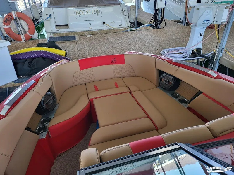 Slide: The Image of 2021 MasterCraft X26 boat interior with red and tan seating, docked at marina. - 24
