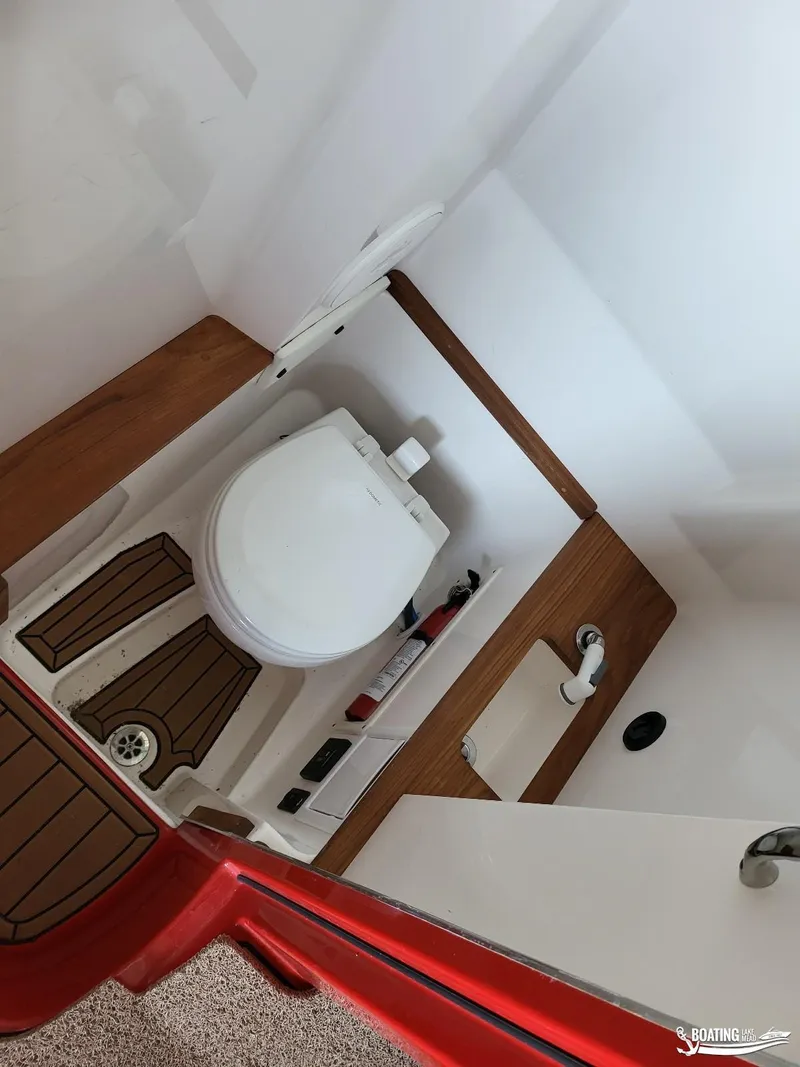 Slide: The Image of 2021 MasterCraft X26 boat bathroom interior with wooden accents and modern fixtures. - 31