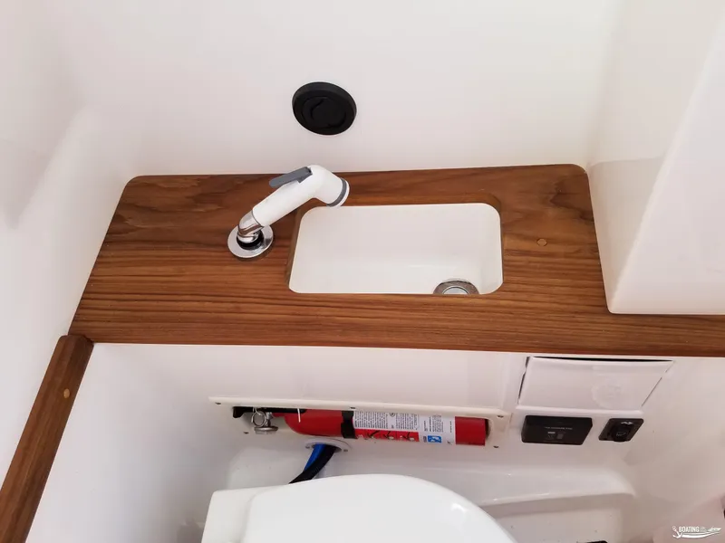 Slide: The Image of 2021 MasterCraft X26 boat interior with wooden sink and fire extinguisher. - 33