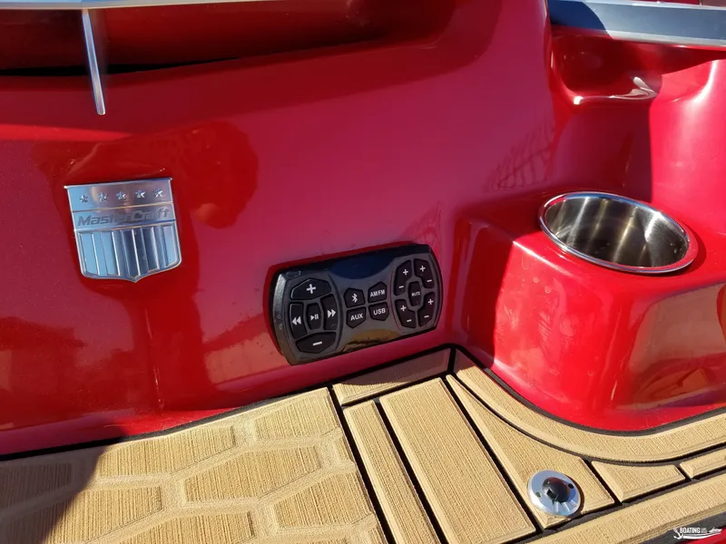 Slide: The Image of Red 2021 MasterCraft X26 boat dashboard with control panel and cup holder. - 34