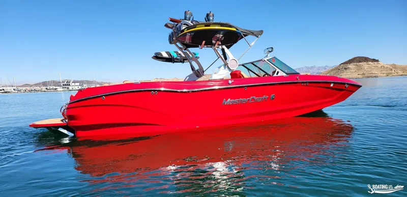Slide: The Image of 2021 MasterCraft X26 boat in vibrant red on a serene lake. - 4