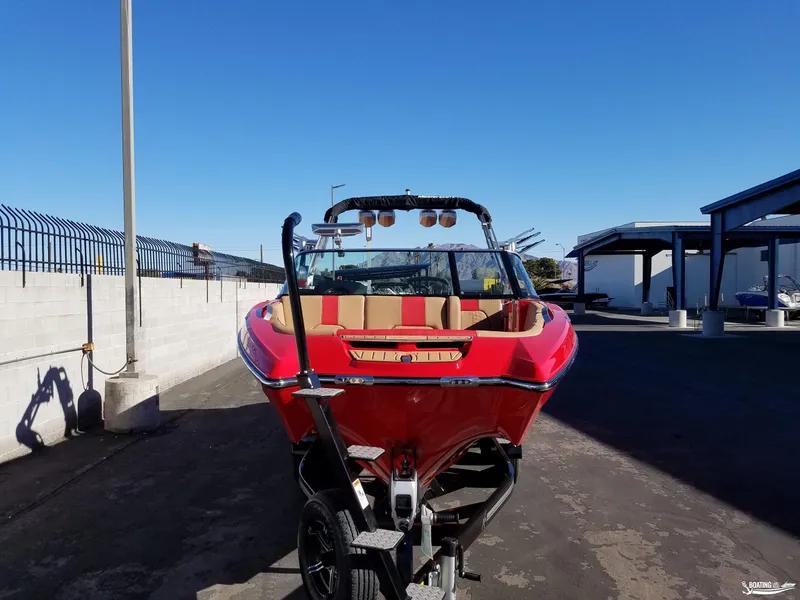 Slide: The Image of 2021 MasterCraft X26 boat in vibrant red on a trailer, parked outdoors. - 9