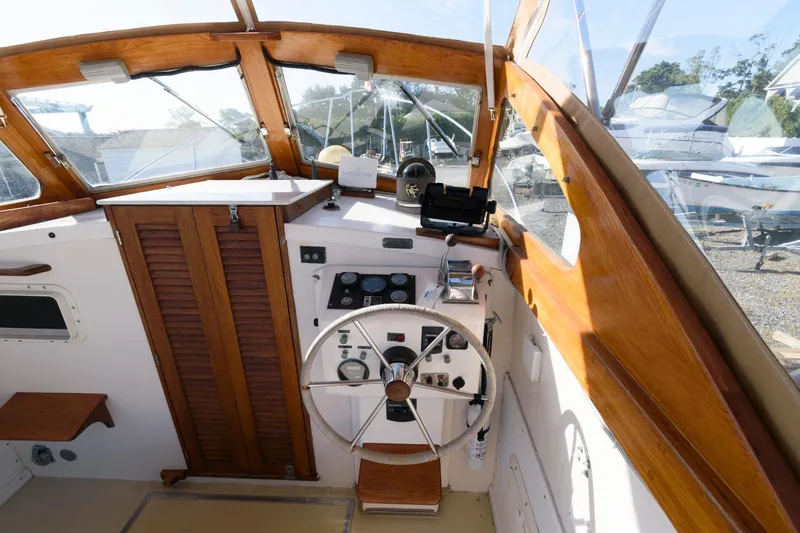 Slide: The Image of 1983 Dyer 29 Downeast Express boat cockpit with wooden accents and steering wheel. - 10