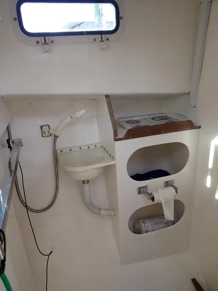 Slide: The Image of 1983 Dyer 29 Downeast Express boat interior with sink and storage compartments. - 19