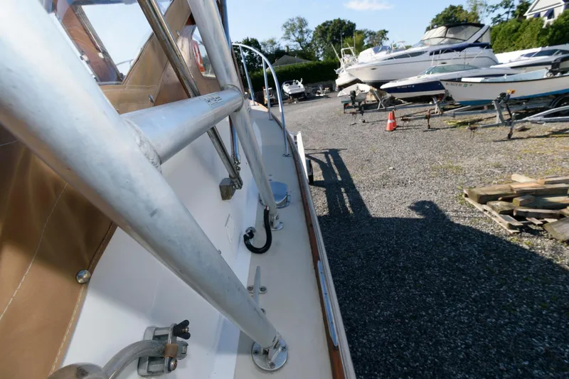 Slide: The Image of 1983 Dyer 29 Downeast Express boat on gravel lot with other boats. - 8