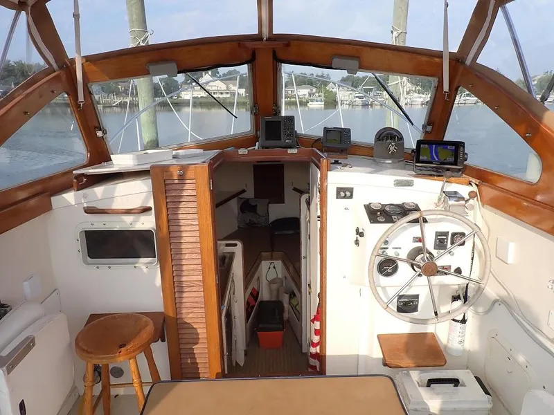 Slide: The Image of 1983 Dyer 29 Downeast Express boat cockpit with wooden accents and navigation equipment. - 9