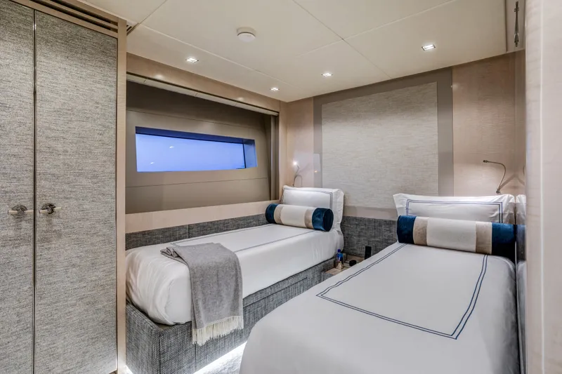 Slide: The Image of Luxurious 2023 Mangusta Gransport yacht cabin with twin beds and modern decor. - 26