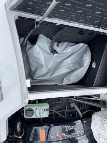 Slide: The Image of 2015 Tigé Z1 boat engine compartment with storage area and hoses. - 11