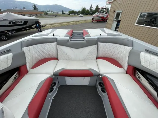 Slide: The Image of 2015 Tigé Z1 boat interior with red and white seating, docked near a Malibu boat. - 7