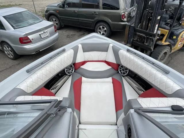 Slide: The Image of 2015 Tigé Z1 boat interior with red and white seating, parked near vehicles. - 9