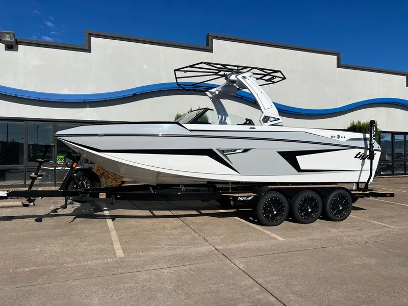 Slide: The Image of 2025 Tigé 24RZX boat on trailer, sleek design, parked outdoors. - 2