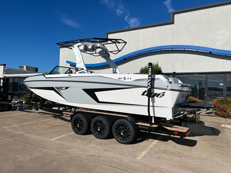Slide: The Image of 2025 Tigé 24RZX boat on trailer, parked outdoors under clear blue sky. - 3