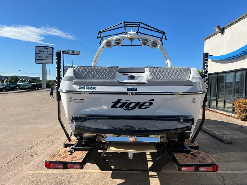 Slide: The Image of 2025 Tigé 24RZX boat on trailer, rear view, sunny day at dealership. - 4