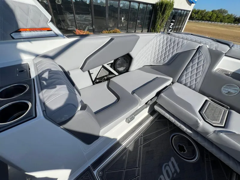 Slide: The Image of 2025 Tigé 24RZX boat interior with gray quilted seating and cup holders. - 8