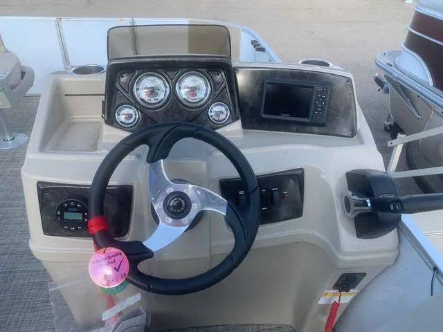 Slide: The Image of 2023 SunCatcher Select 18F boat dashboard with steering wheel and gauges. - 4