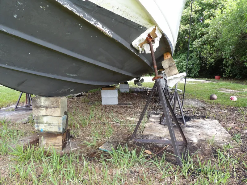 Slide: The Image of Damaged 2005 Sea Ray 360 Sundancer boat hull on supports, grassy area. - 10