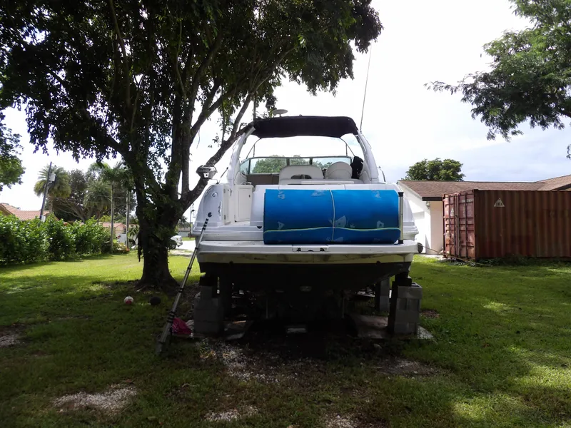 Slide: The Image of 2005 Sea Ray 360 Sundancer boat on land, surrounded by trees. - 16