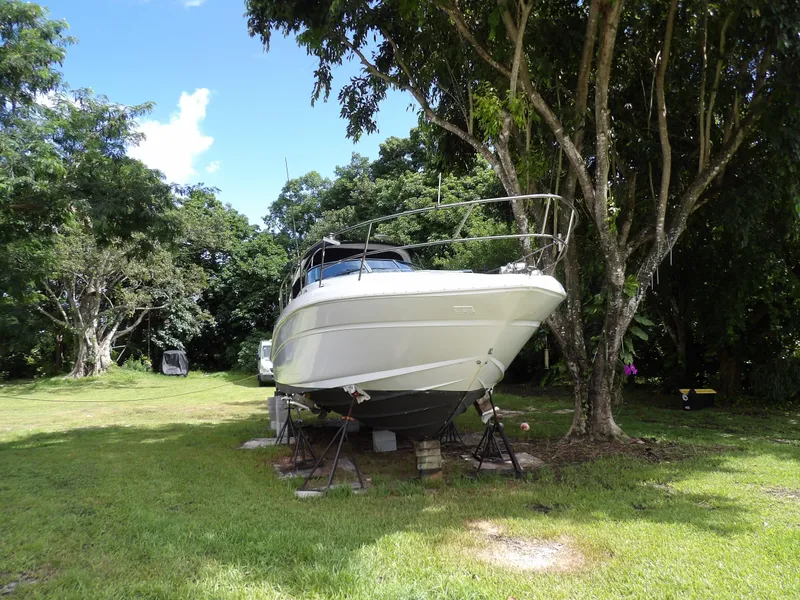 Slide: The Image of 2005 Sea Ray 360 Sundancer boat on land, surrounded by trees. - 2