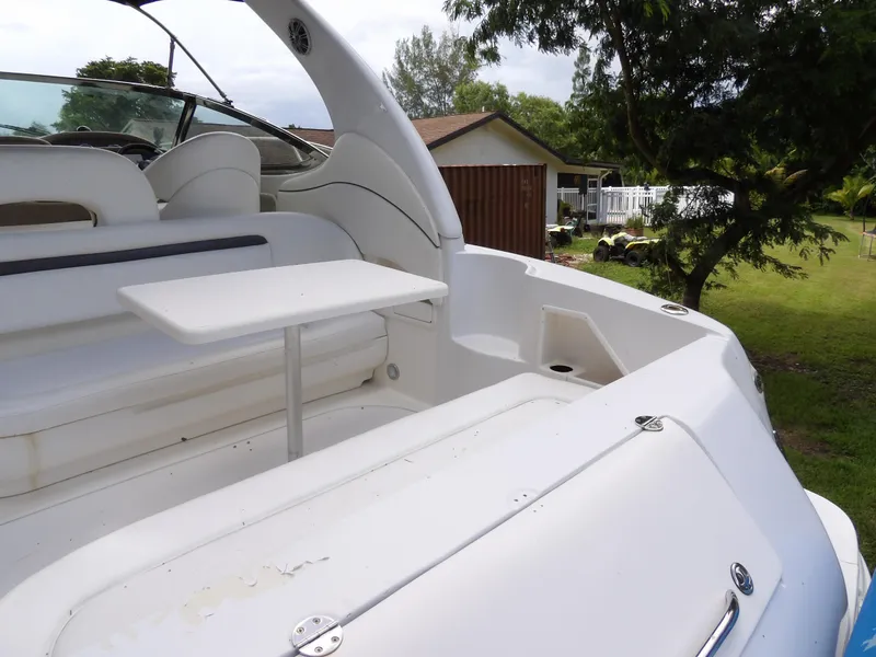 Slide: The Image of 2005 Sea Ray 360 Sundancer boat interior with seating and table, docked near greenery. - 25