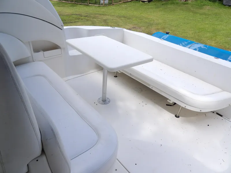 Slide: The Image of 2005 Sea Ray 360 Sundancer boat seating area with white cushions and table. - 34
