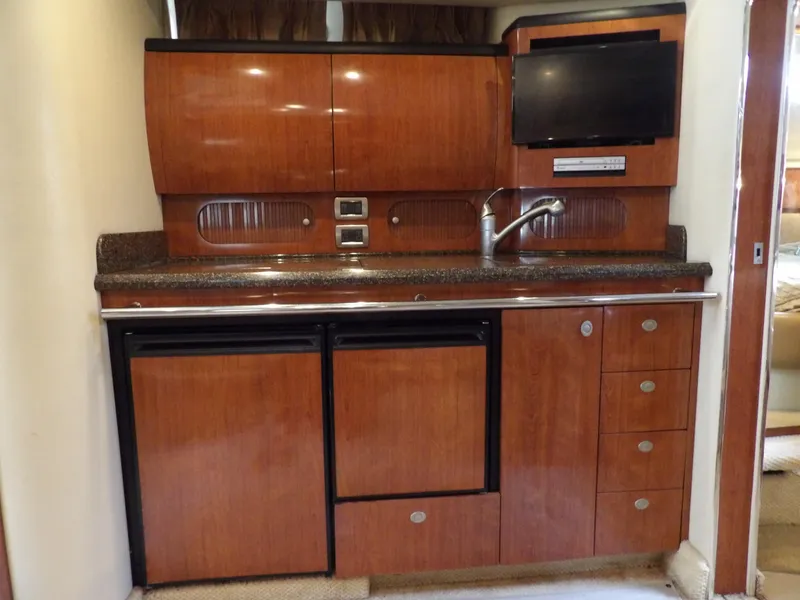 Slide: The Image of 2005 Sea Ray 360 Sundancer kitchen with wood cabinets, sink, and TV. - 43