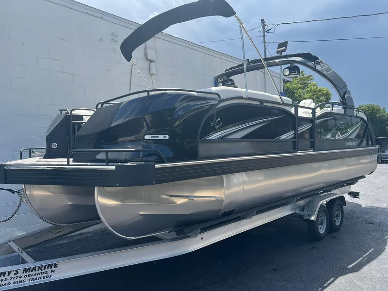 Slide: The Image of 2025 JC 26 SportToon TT DSL pontoon boat on trailer, sleek black design. - 1