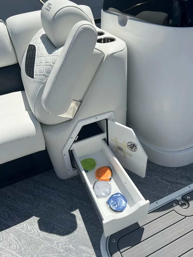 Slide: The Image of 2025 JC 26 SportToon TT DSL boat with open storage drawer and colorful items. - 20