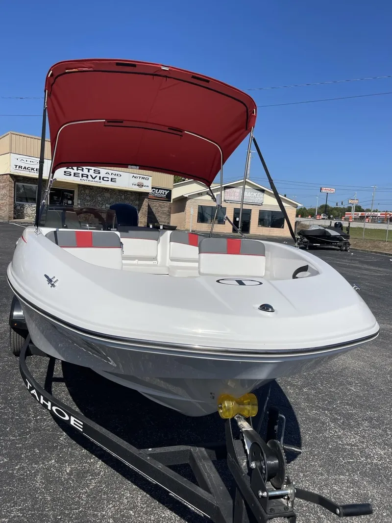 Slide: The Image of 2024 Tahoe T16 boat with red canopy on trailer, parked outdoors. - 3