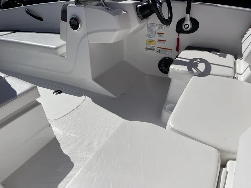 Slide: The Image of 2024 Tahoe T16 boat interior with white seating and steering console. - 5