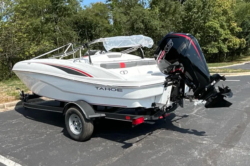 Slide: The Image of 2024 Tahoe T18 boat on trailer, parked outdoors, featuring sleek design and powerful outboard motor. - 2