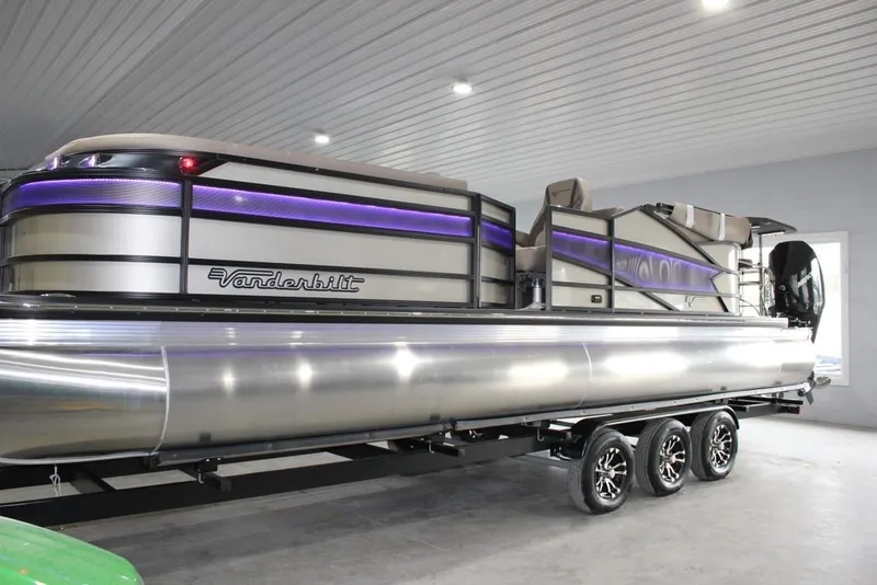 The Image of 2022 Vanderbilt 700SC pontoon boat with sleek design and modern features in a showroom. - 1