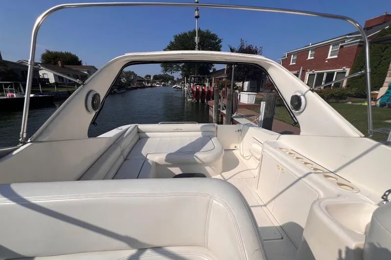 Slide: The Image of 2000 Wellcraft 45 Excalibur boat interior with white seating, docked in a canal. - 13