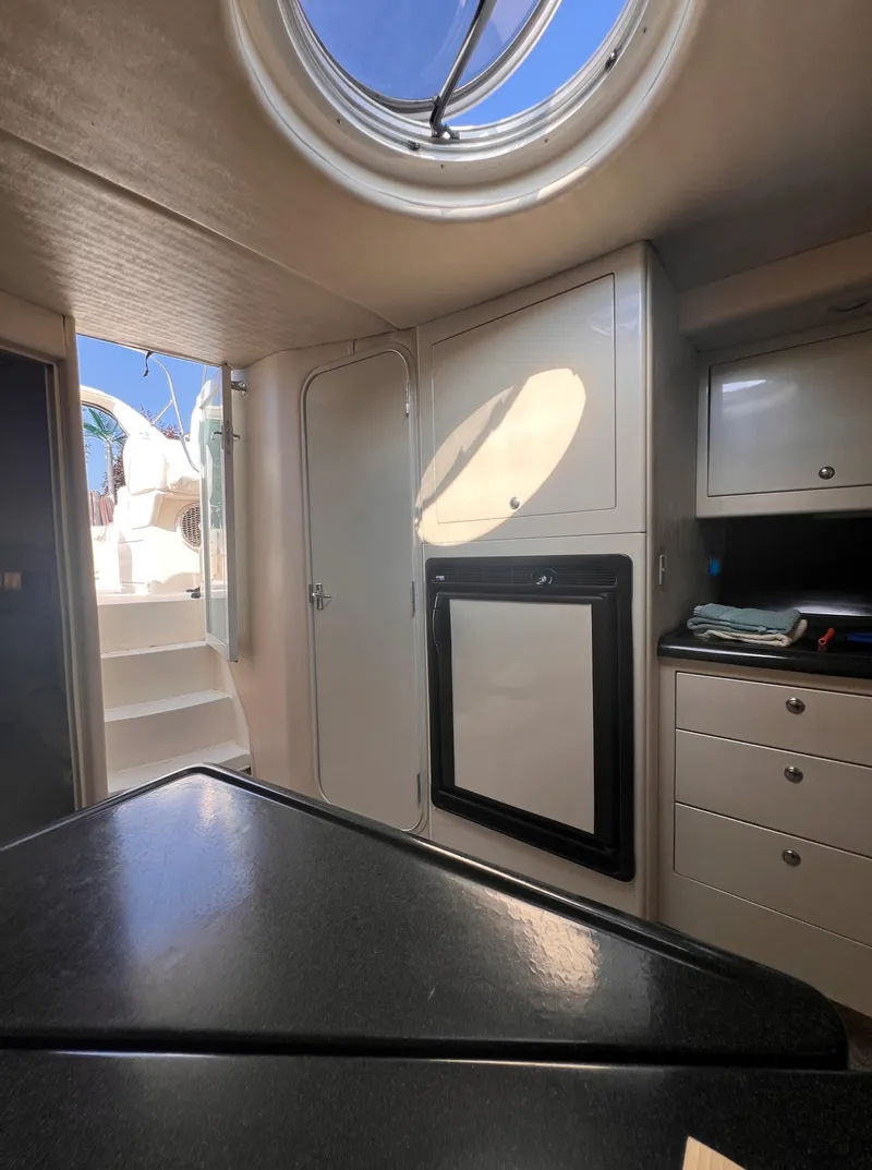 Slide: The Image of Interior of 2000 Wellcraft 45 Excalibur yacht, featuring modern cabinetry and porthole window. - 22