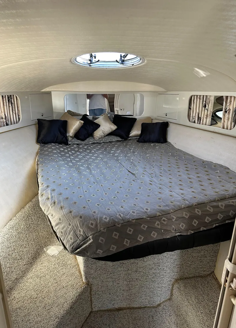 Slide: The Image of Cozy cabin interior of 2000 Wellcraft 45 Excalibur with plush bedding and pillows. - 27