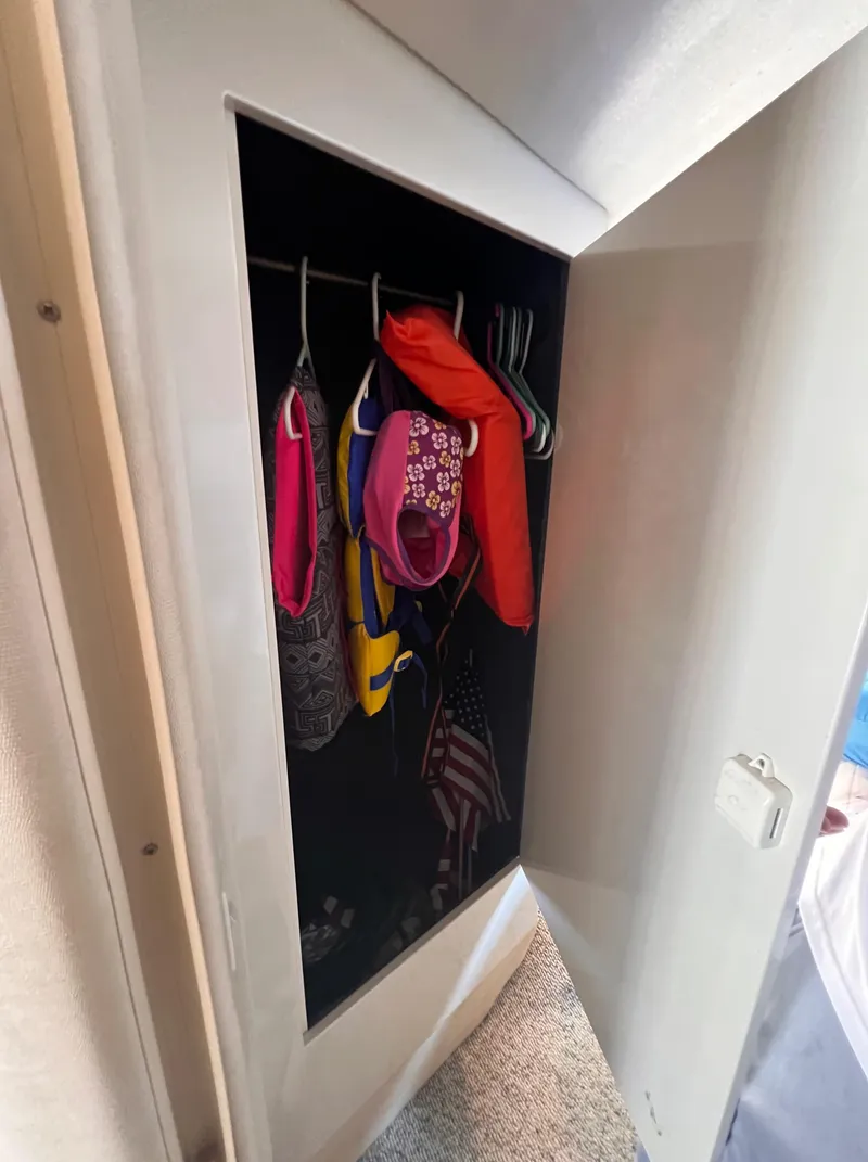 Slide: The Image of Storage closet on 2000 Wellcraft 45 Excalibur boat with life jackets and American flag. - 31