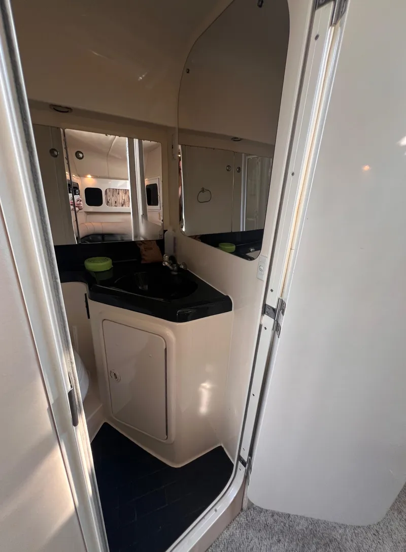 Slide: The Image of Interior of 2000 Wellcraft 45 Excalibur boat, featuring a compact bathroom area. - 38