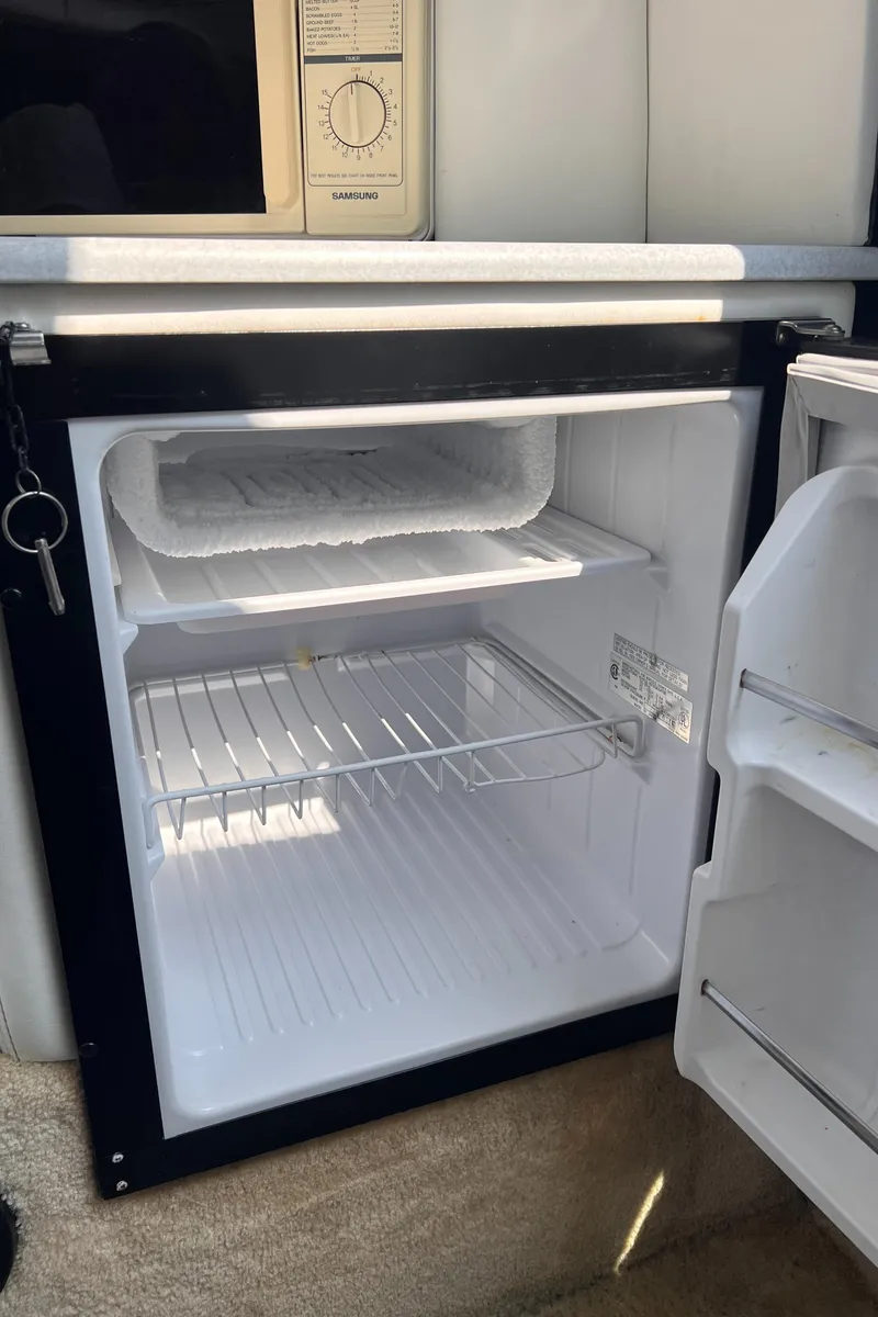 Slide: The Image of Open mini fridge inside 1995 Powerquest 290 Enticer FX boat cabin. - 11