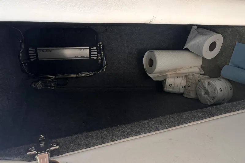 Slide: The Image of Storage compartment in 1995 Powerquest 290 Enticer FX with audio equipment and paper rolls. - 14