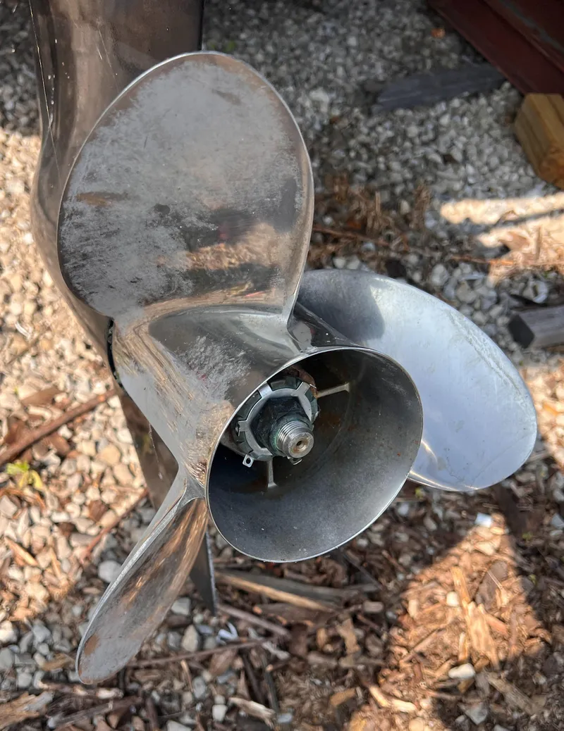 Slide: The Image of Close-up of a 1995 Powerquest 290 Enticer FX boat propeller on gravel. - 24