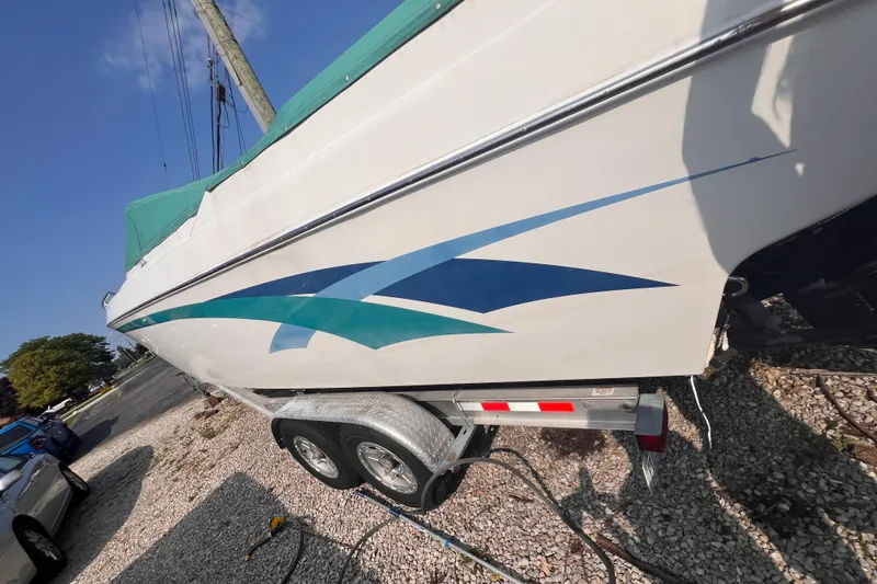 Slide: The Image of 1995 Powerquest 290 Enticer FX boat on trailer, featuring blue and teal graphics. - 28