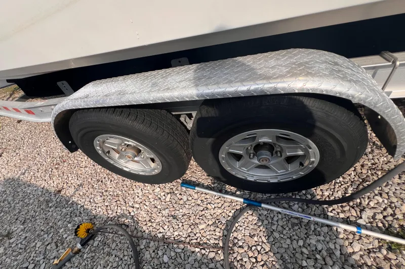 Slide: The Image of Trailer wheels of a 1995 Powerquest 290 Enticer FX on gravel. - 29